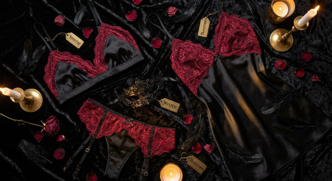 A moody editorial flat lay of black and crimson silk lingerie arranged with feathers, rose petals, and a masquerade mask on dark velvet, lit by warm candlelight.